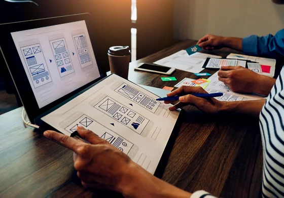 Wireframe designer working with laptop and phone